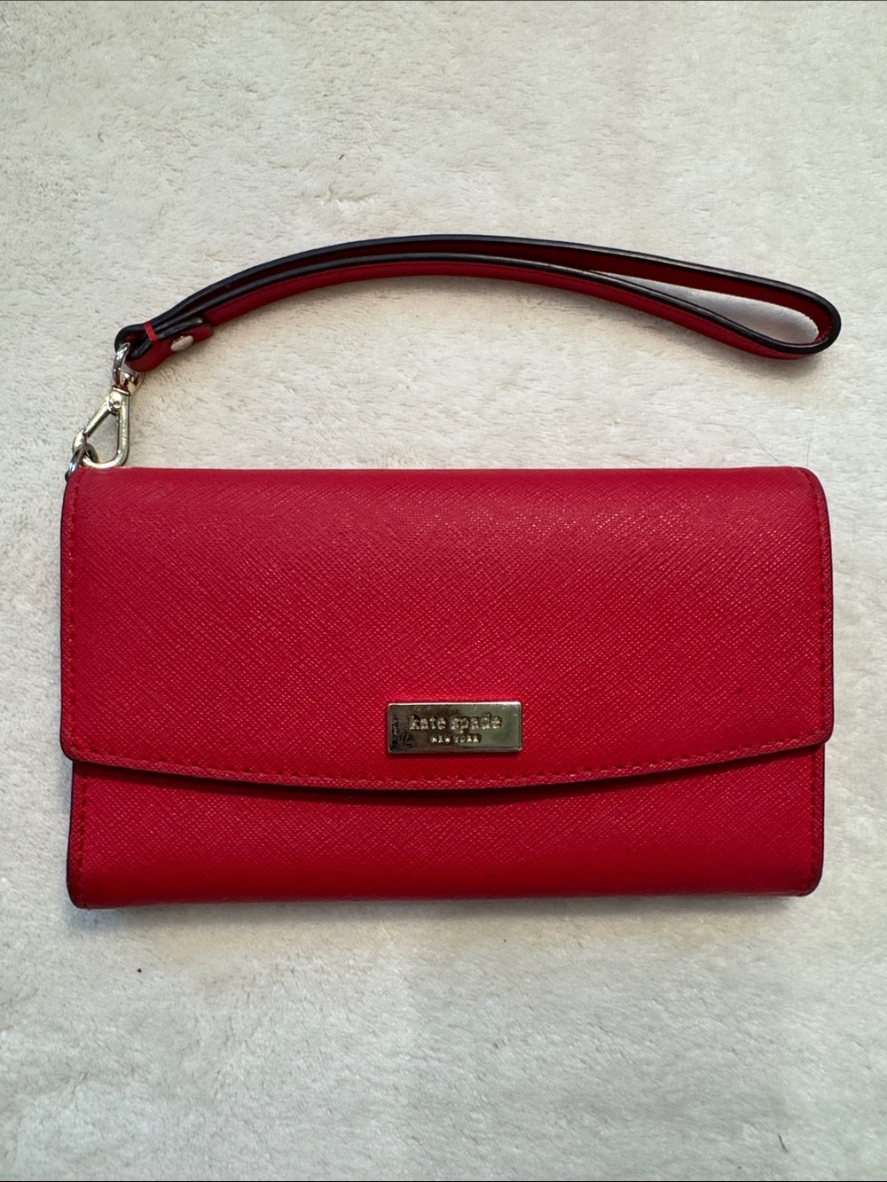 Kate Spade red wallet with wrist strap.